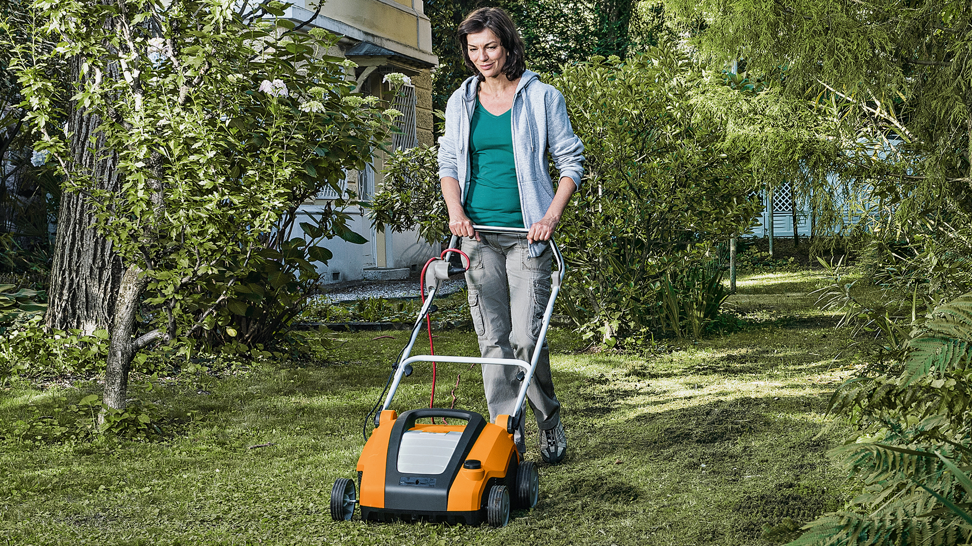Nainen työskentelee puutarhassa STIHL RLE 240 -nurmikon ilmaajan kanssa