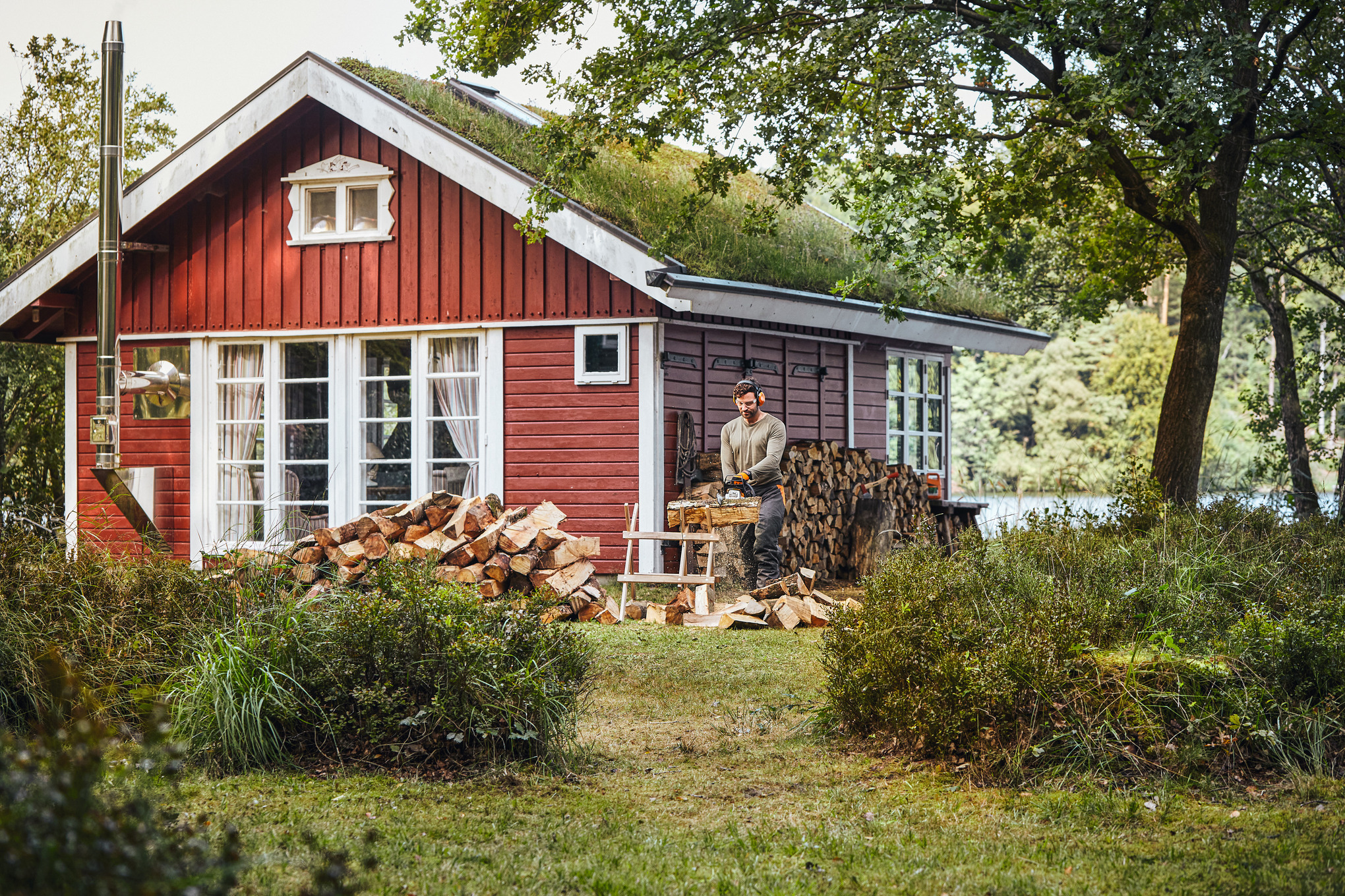 Mies työskentelee moottorisahalla