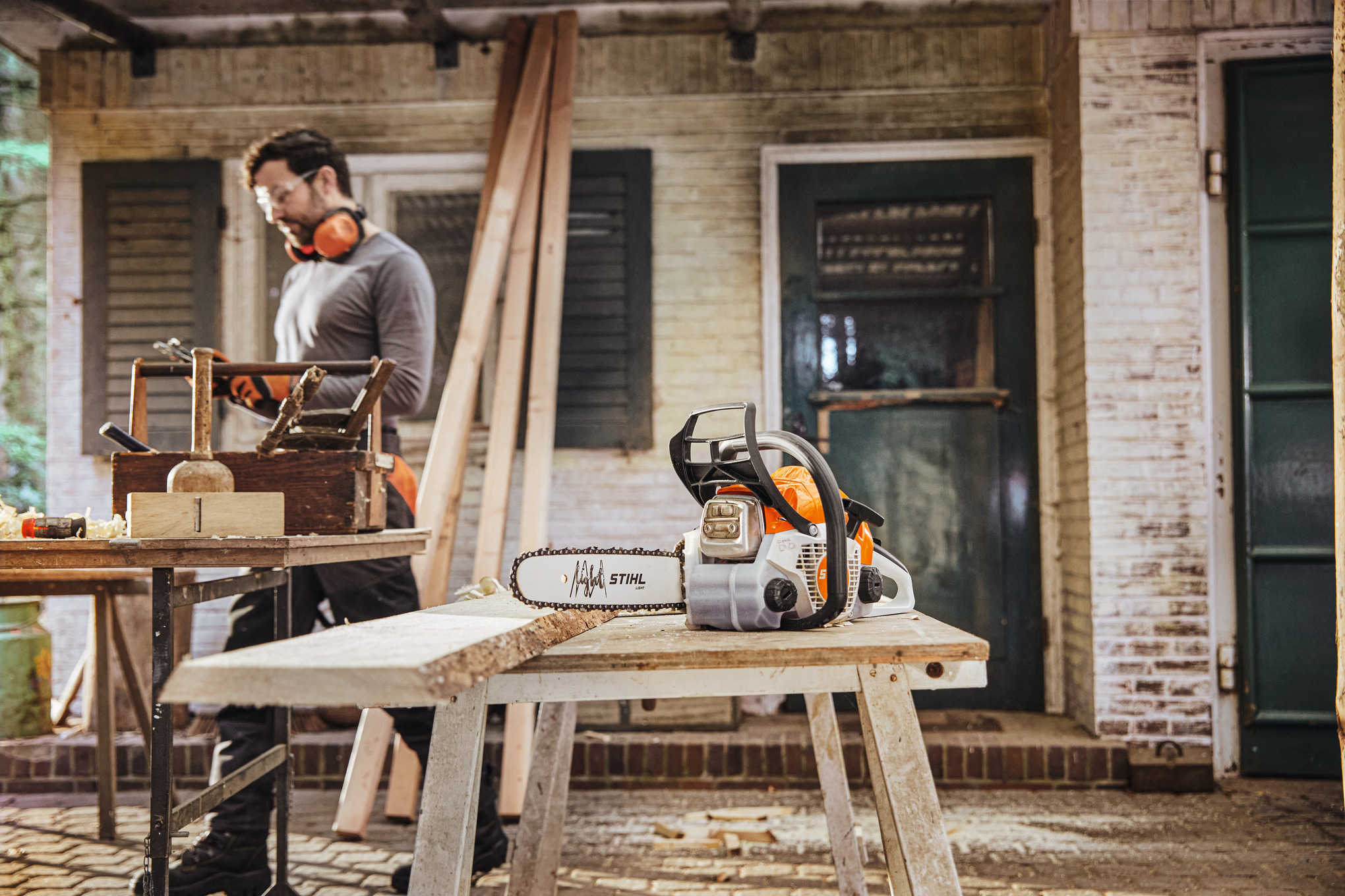 STIHL moottorisaha, taustalla mies