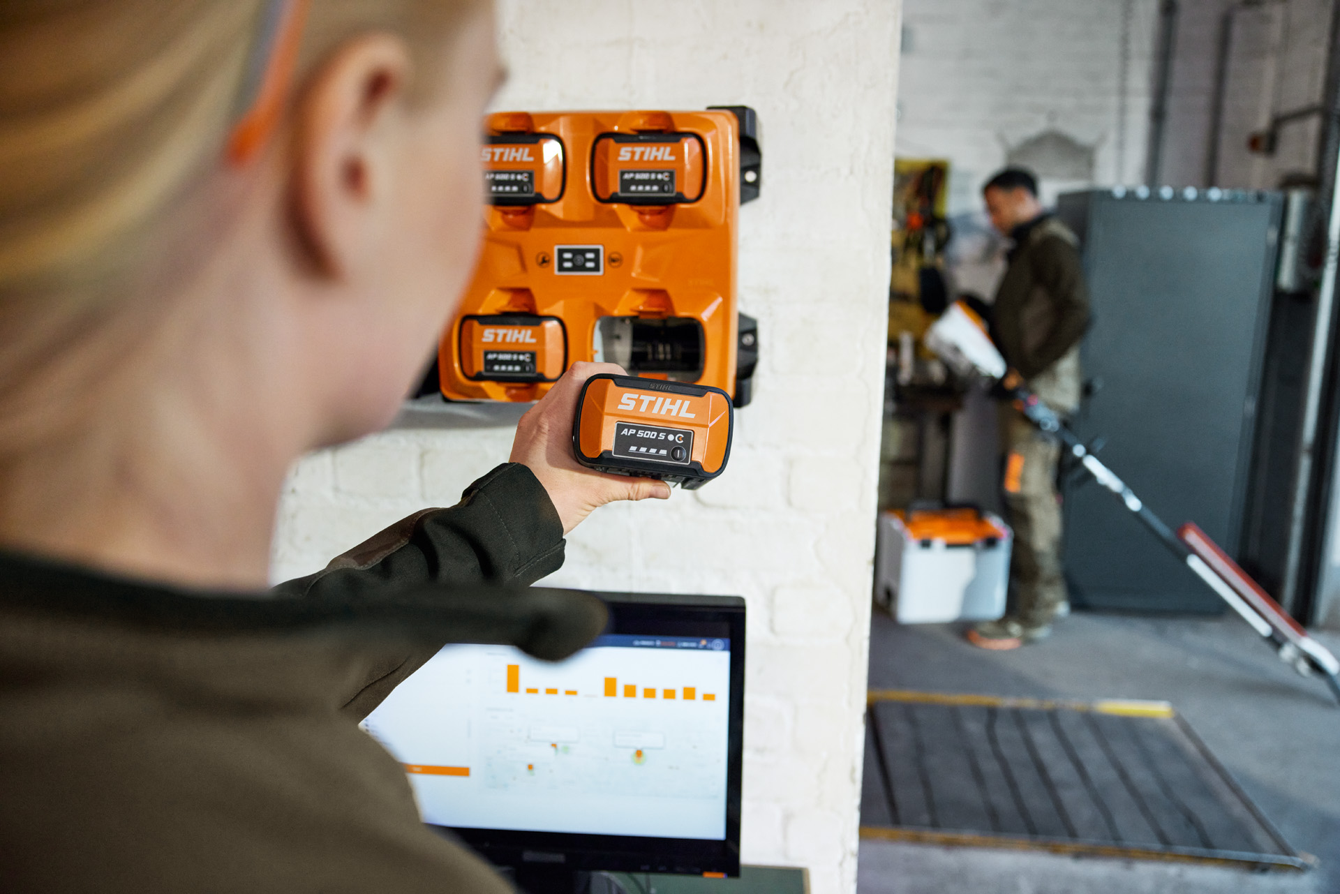 Nainen kannettavan tietokoneen edessä ottamassa AP 300 S -laitetta STIHL AL 301-4 -monilaturista