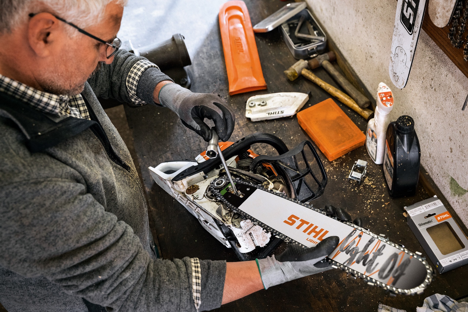 STIHL-jälleenmyyjä huoltamassa moottorisahaa, jossa on STIHL Light 04 -laippa ja Oilomatic-ketju