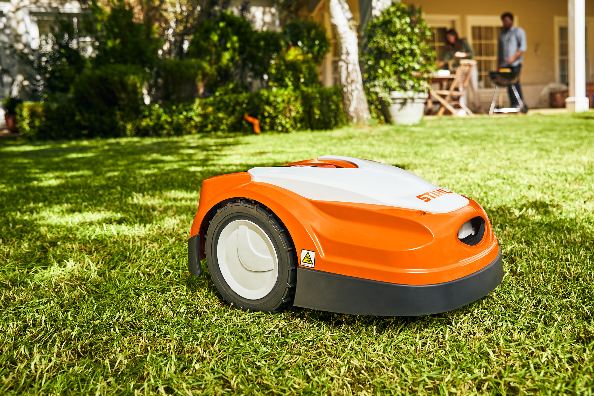 STIHL iMOW® RI 422 -robottiruohonleikkuri vihreällä nurmikolla talon edessä