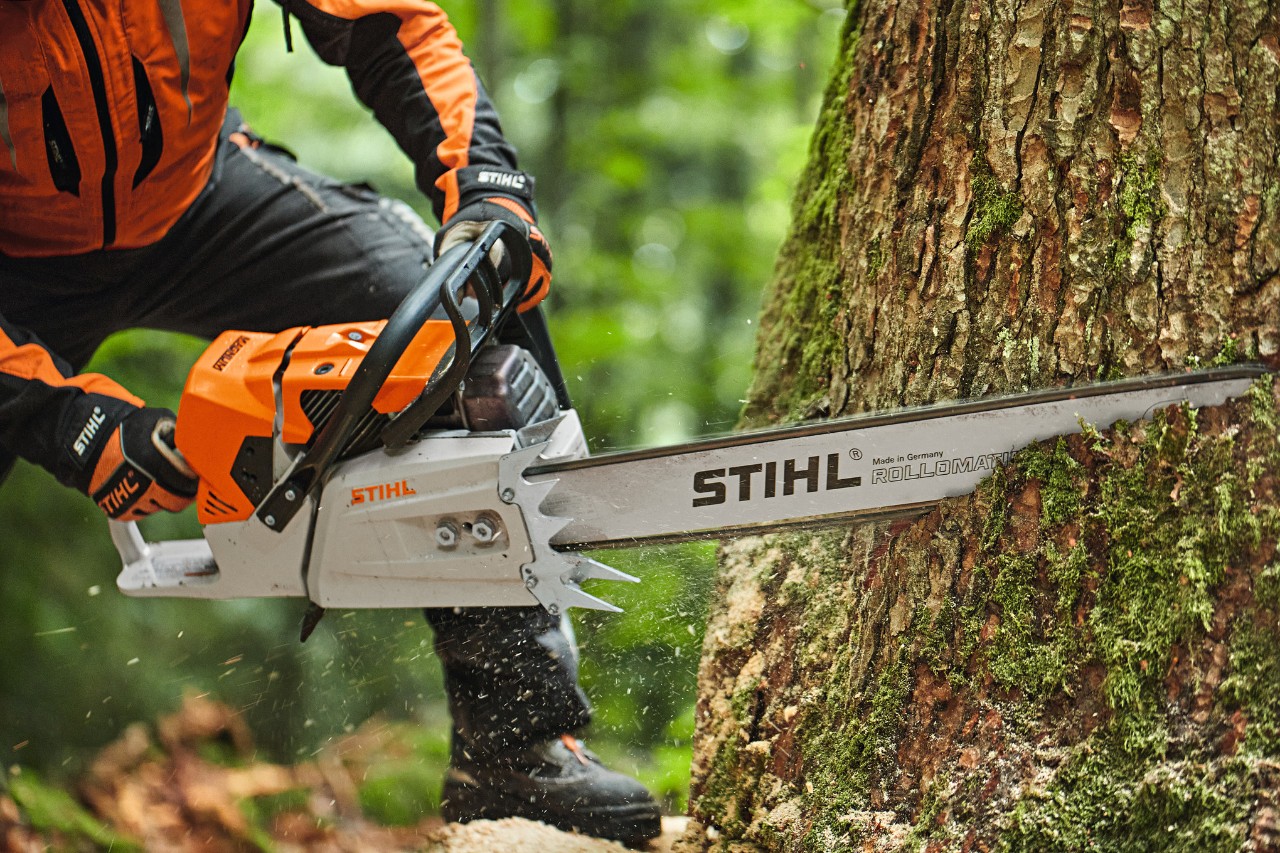 Henkilö sahaamassa puuta bensiinikäyttöisellä STIHL MS 881 -moottorisahalla, jossa on kärkilaippa