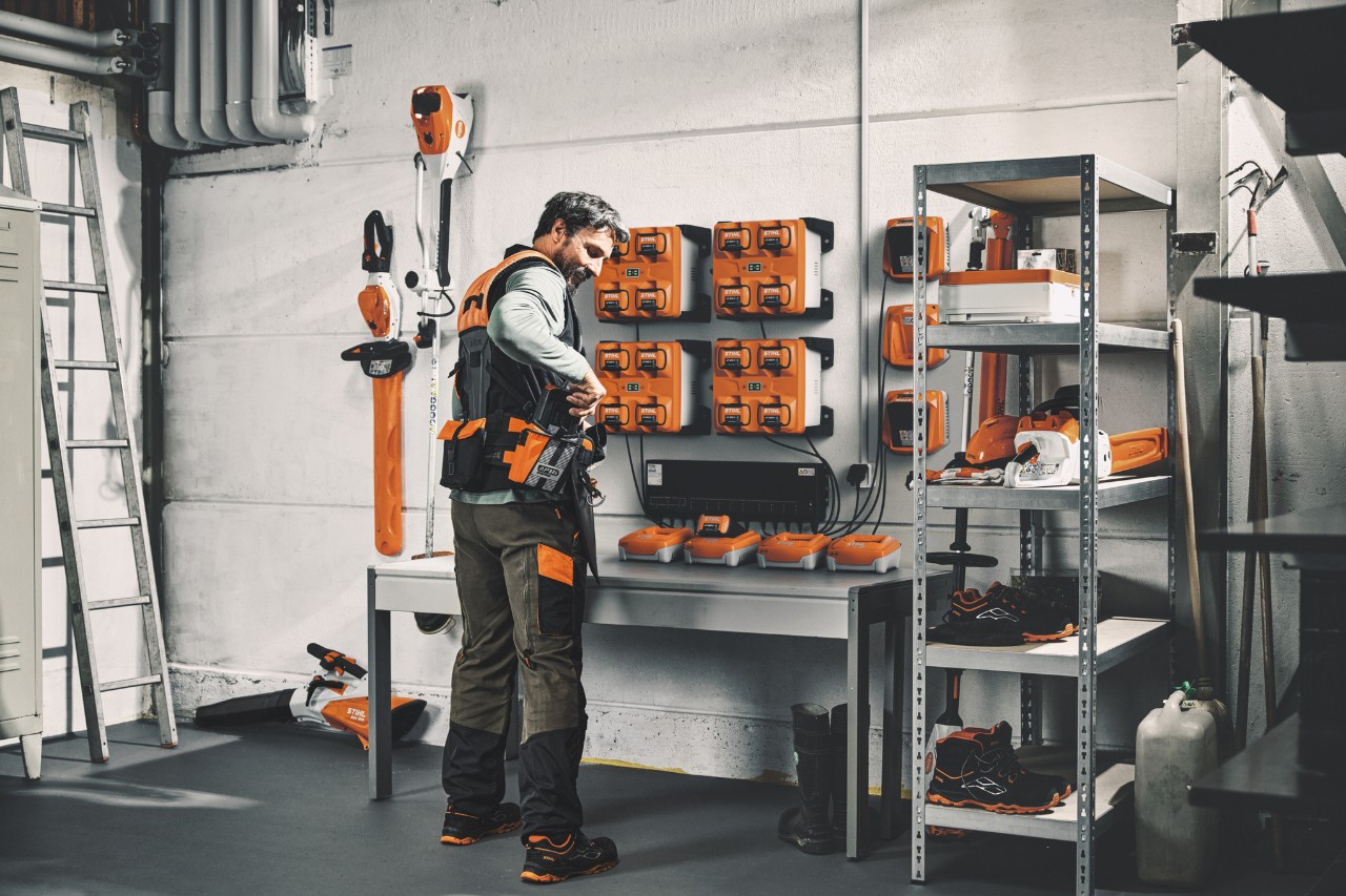STIHL-työkalujen ja akkujen varastohuoneessa oleva mies käyttää modulaarista STIHL ADVANCE X-Flex -valjasjärjestelmää.