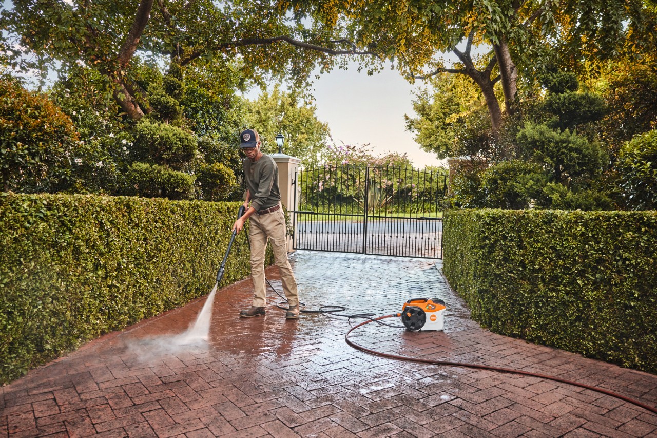 Mies käyttää STIHL REA 100 -painepesuria