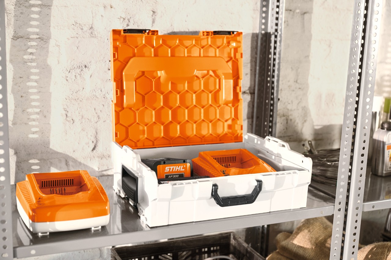 STIHL-akkukotelo ja STIHL-akut työpajan hyllyllä  